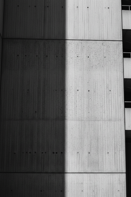 Raw brutalist concrete wall, harsh diagonal light, deep shadow — echelonn. editorial