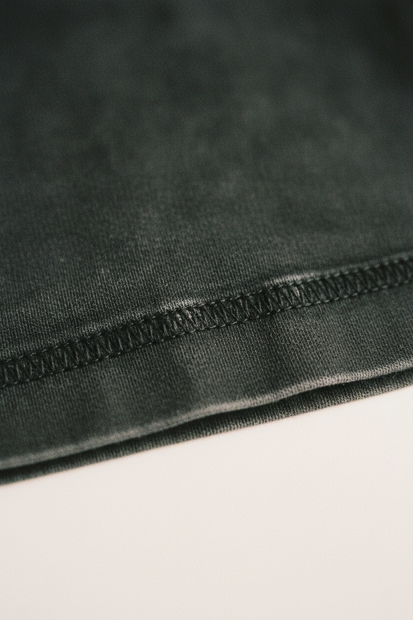 Washed black heavyweight cotton hem detail, overlock stitch, clean fold, echelonn. HQ 001