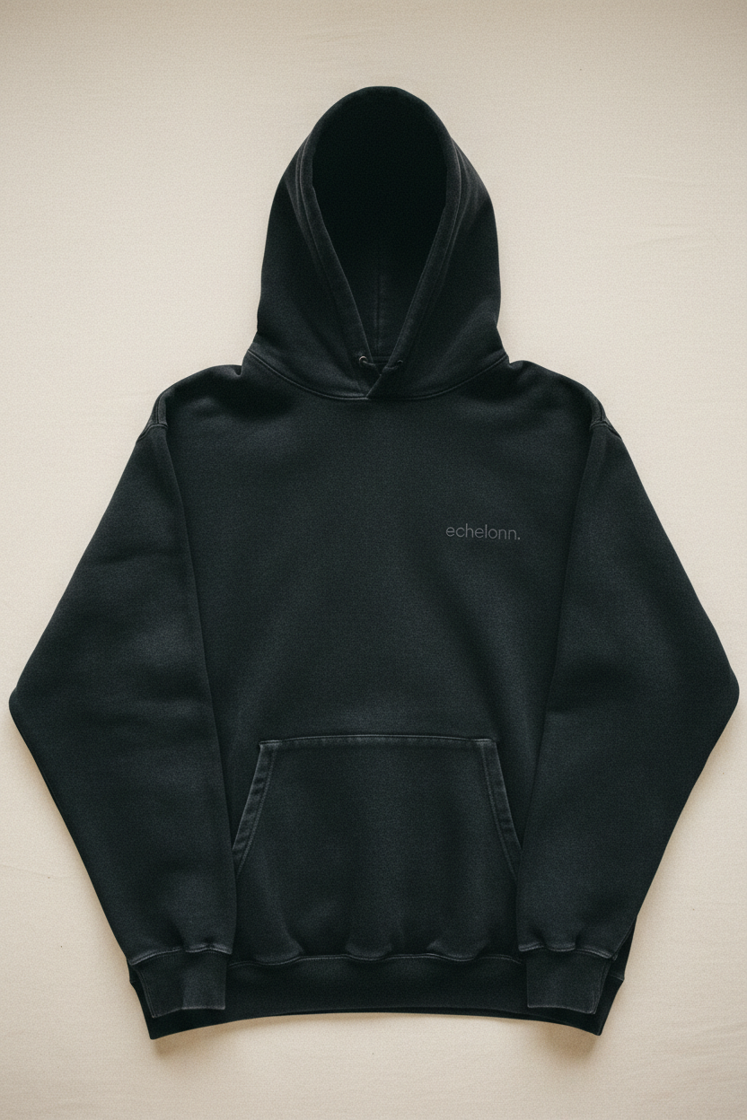 echelonn. aegis. heavyweight hoodie flat lay — washed black 400gsm loop-back fleece, enzyme-washed, tonal echelonn. wordmark on left chest